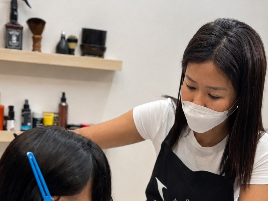 ช่างของร้าน Wewigs Pro กำลังตัดแต่งไรผมและกรอบหน้าของวิกผมให้ลูกค้าในวันติดตั้ง เพื่อให้กลมกลืนกับรูปหน้า