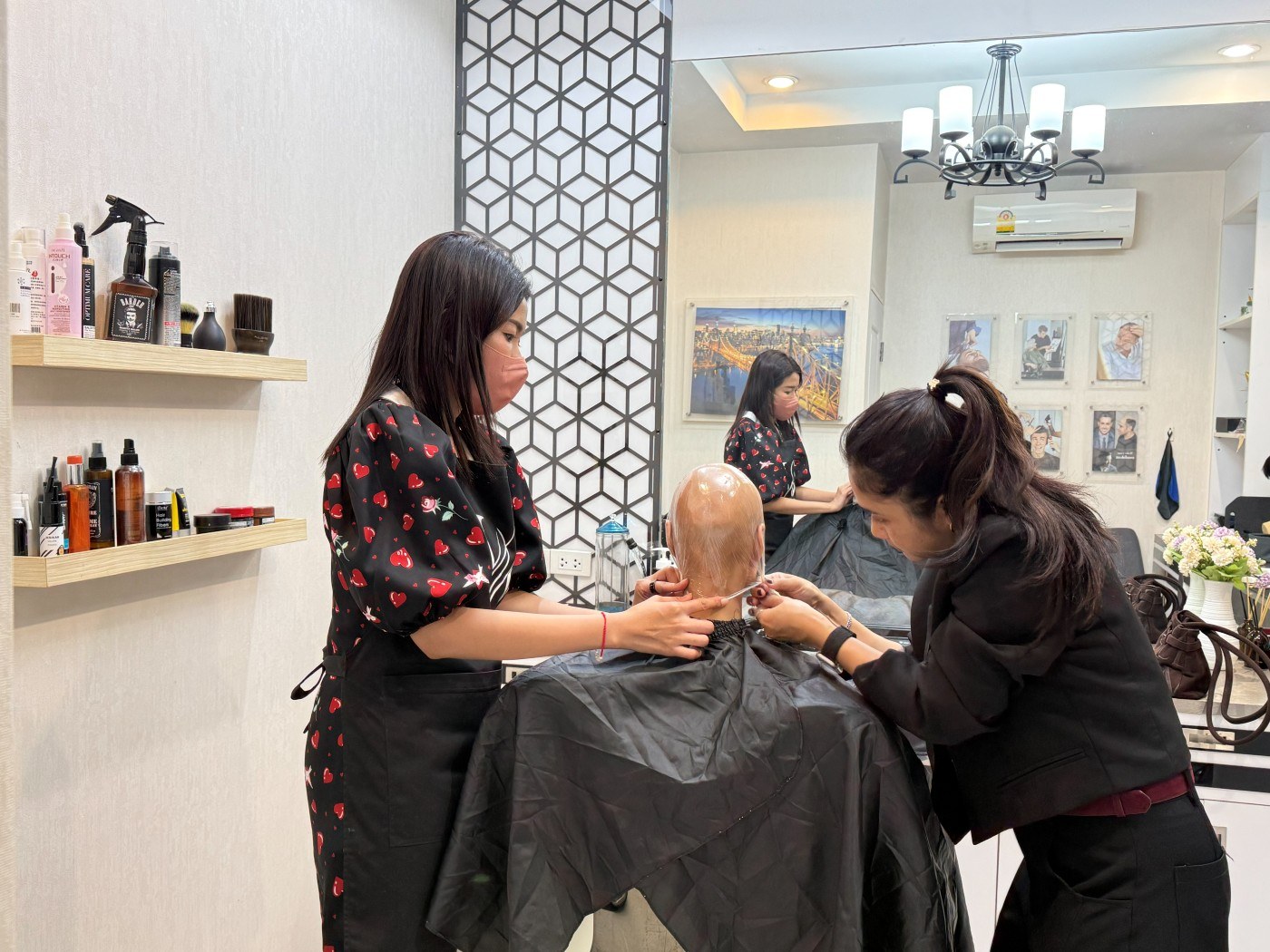ช่างวิกผมสองคนของร้าน Wewigs Pro กำลังทำแบบพิมพ์ศีรษะให้ลูกค้าที่ผมร่วงจากเคมีบำบัด ที่หน้าร้านจรัญสนิทวงศ์ 77 บางพลัด